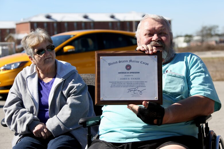 James Tooker is recognized with an award alongside his wife, Betty, aboard Marine Corps Air Station Cherry Point, N.C., Feb. 10, 2017. “It’s not about me, it’s about an individual getting along with other individuals and caring,” said Tooker.  Tooker, a U.S. Army veteran, served 41 years working as the air station civilian fuel inspector. (U.S. Marine Corps photo by Cpl. Jason Jimenez/ Released)