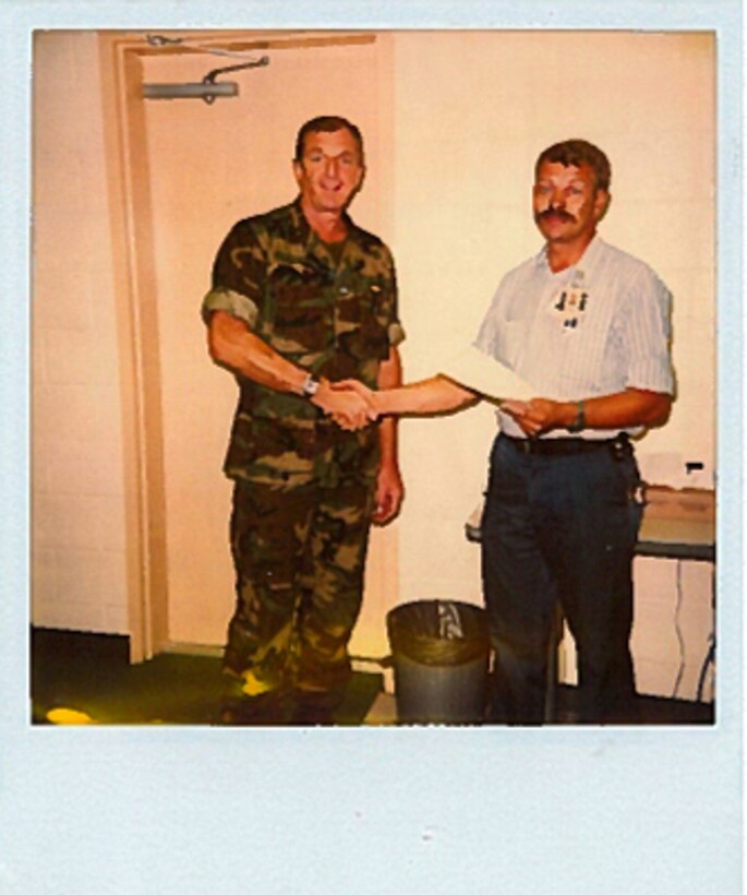 Brig. Gen. (ret.) James Meade, left, congratulates James Tooker, for achieving an award of recognition in the mid-1980s aboard Marine Corps Air Station Cherry Point, N.C.  Tooker began working on the air station in 1981 as a worker trainee.  Known as Jimmy by his coworkers, he retired Jan. 30, 2017. (Courtesy photo/ Released)