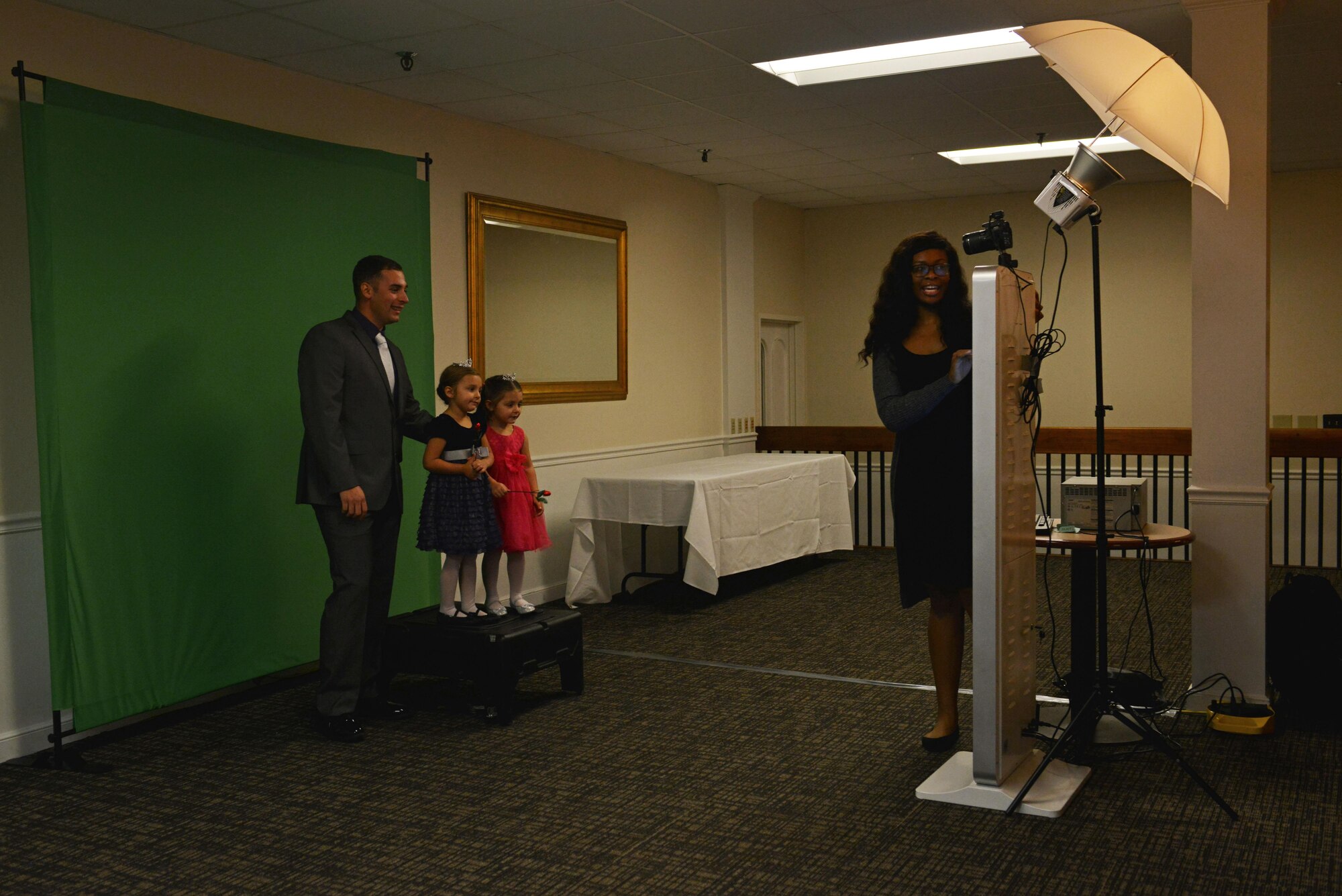 A Team Shaw family stands in front of a green screen for a picture during a “Royal Affair” father-daughter princess ball at Shaw Air Force Base, S.C., Feb. 18, 2017. Guests of the father-daughter dance were given the opportunity to take pictures with a studio photographer, dance to music provided by a disc jockey and take part in other various activities. (U.S. Air Force photo by Airman 1st Class Destinee Sweeney)