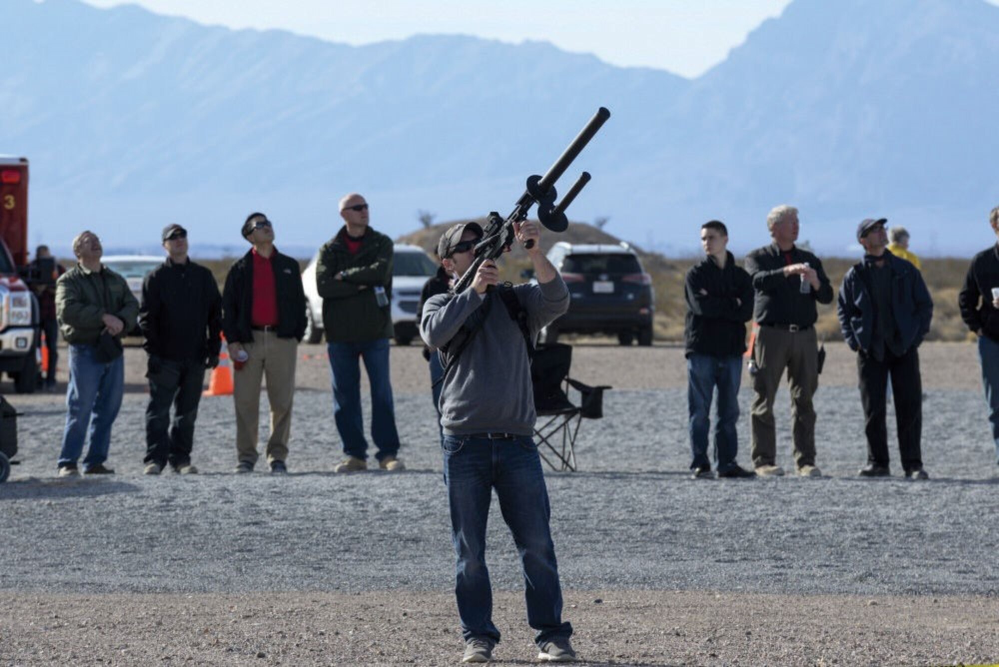 Justin Simpson, a member of the Kirtland Air Force Base team, aims a signal-jamming device at an unmanned aerial system as judges and range personnel watch Dec. 12 during the 2016 Air Force Research Laboratory Commander's Challenge at the Nevada National Security Site near Las Vegas, Nevada. Teams were given six months to develop a complete system to aid in base defense. Kirtland's system is able to detect, identify and track unmanned aerial systems with the capability of engaging through signal jamming and capture using a net gun.