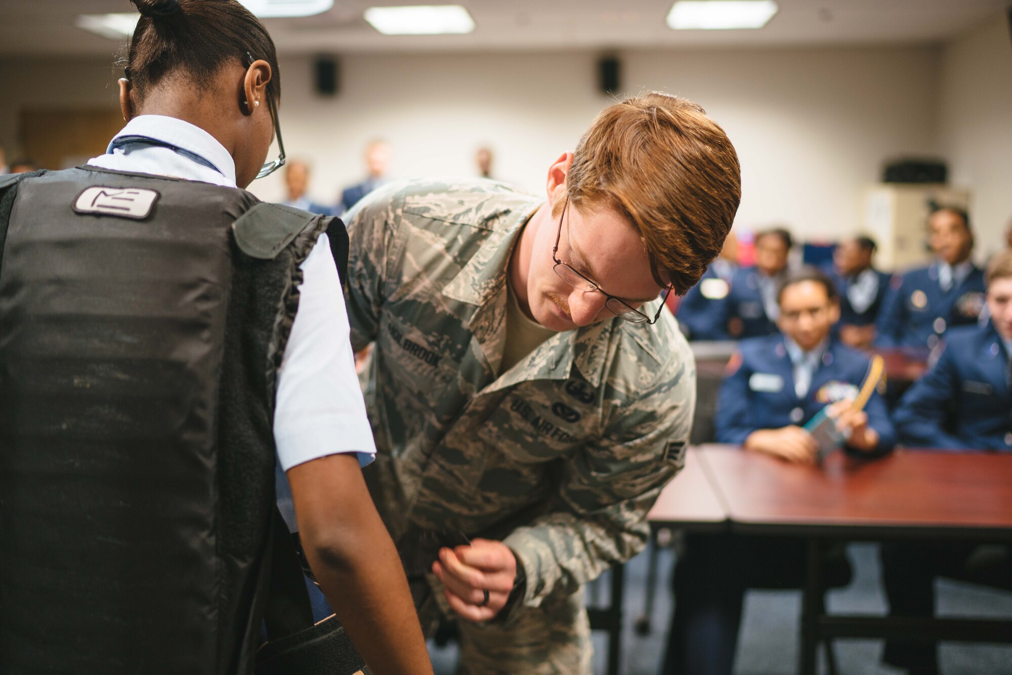 Senior Airman Joshua Holbrook, 11th Civil Engineer Squadron explosive ordinance disposal technician, helps a Baltimore Polytechnic Institute High School Air Force Junior Reserve Officer Training Corps cadet try on EOD protective gear at Joint Base Andrews, Md., Feb. 16, 2017. The tour is part of an annual visitation program with the Air Education and Training Command and sponsored ROTC and JROTC programs. (U.S. Air Force photo by Senior Airman Delano Scott)