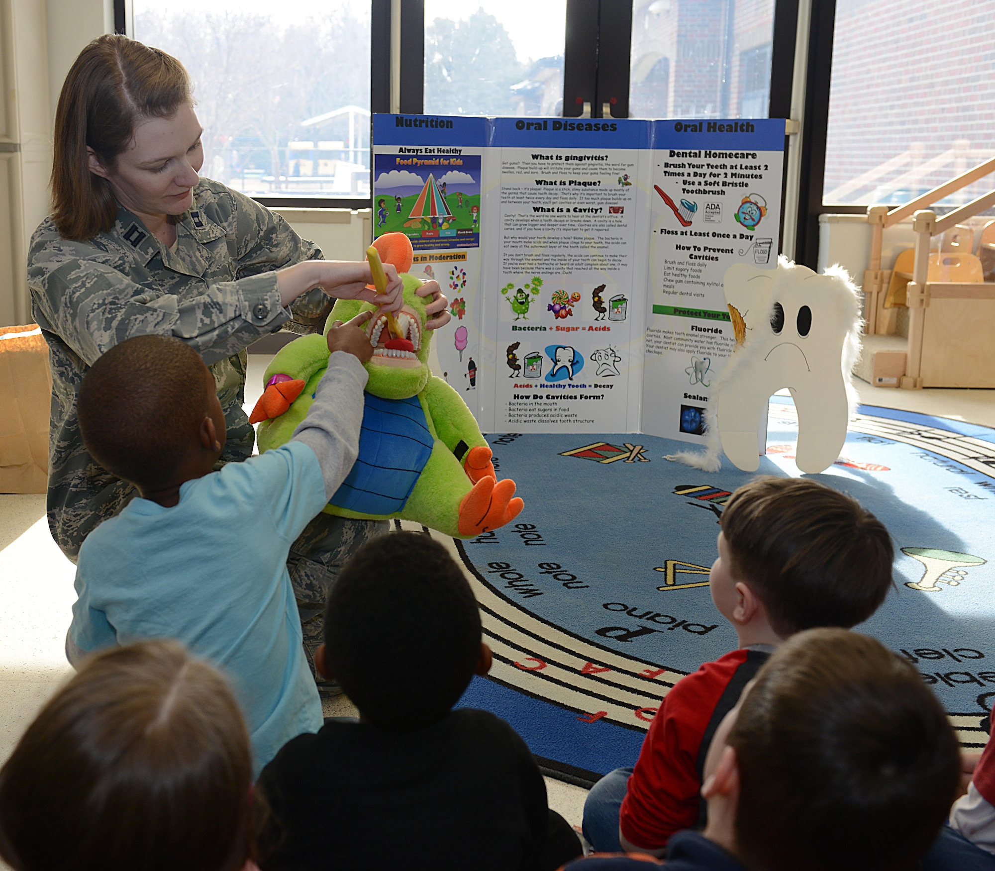 U.S. Air Force Capt. Christina Wengler, 633rd Dental Squadron dentist, demonstrates proper brushing techniques with children at the Langley Child Development Center at Joint Base Langley-Eustis, Va., Feb. 21, 2017. Dentists visited with all age groups at the CDCs to discuss oral hygiene techniques. (U.S. Air Force photo by Staff Sgt. Teresa J. Cleveland)