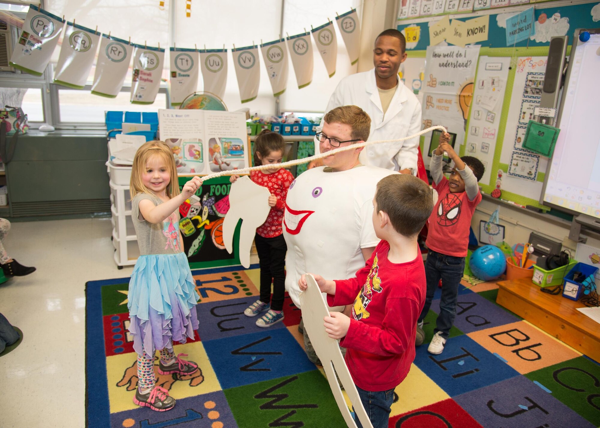 Tech Sgt. Christopher Elam and Airman 1st Class Craig Potts, 436th Aerospace Medicine Squadron dental assistants, show kindergarten students how to floss their teeth Feb. 15, 2017, at Welch Elementary School on Dover Air Force Base, Del. The National Children’s Dental Health month is an observance dedicated to promoting good oral hygiene to students. (U.S. Air Force photo by Mauricio Campino)