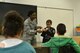 U.S. Air Force Senior Airman Maricia Williams, 20th Dental Squadron oral preventative assistant, demonstrates flossing techniques to a class during a visit to High Hills Elementary School at Shaw Air Force Base, S.C., Feb. 15, 2017. Williams asked for a volunteer to help her the techniques, the volunteer’s fists were used as the “teeth” and the rope was used as the “floss.” (U.S. Air Force photo by Airman 1st Class Destinee Sweeney)