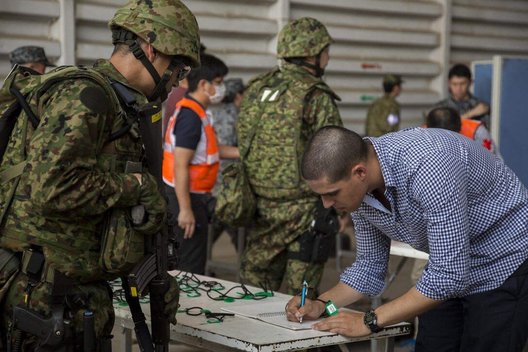 A Japan Air Self-Defense Force member helps process a role player during a noncombatant evacuation operation, as part of Cobra Gold 17 at Naval Airbase Utapao, Thailand, Feb. 19, 2017. The drill was conducted to exercise joint, multinational cooperation during disaster relief. Cobra Gold is the largest Theater Security Cooperation exercise in the Indo-Asia-Pacific region and is an integral part of the U.S. commitment to strengthen engagement in the region. U.S., Thai, Malaysian and Japanese forces participated in the disaster relief drill.