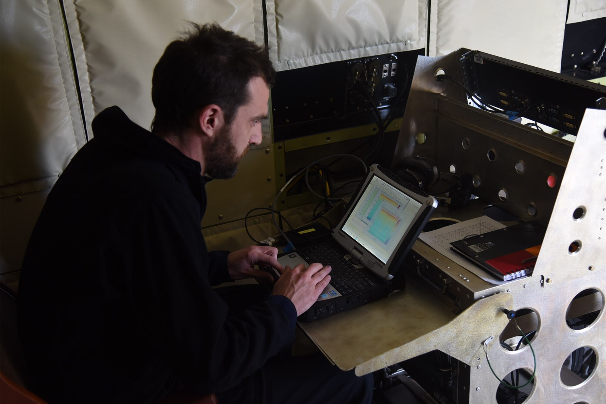 PETERSON AIR FORCE BASE, Colo.—A NASA crew member aboard the P-3 Orion aircraft at Peterson Air Force Base, Colorado, reviews snow pack data Feb. 17 from flights over Grand Mesa, Colorado. This data is being compiled from multiple flights to be compared with measurements on the ground for the SnowEx mission. (U.S. Air Force photo by Robb Lingley)