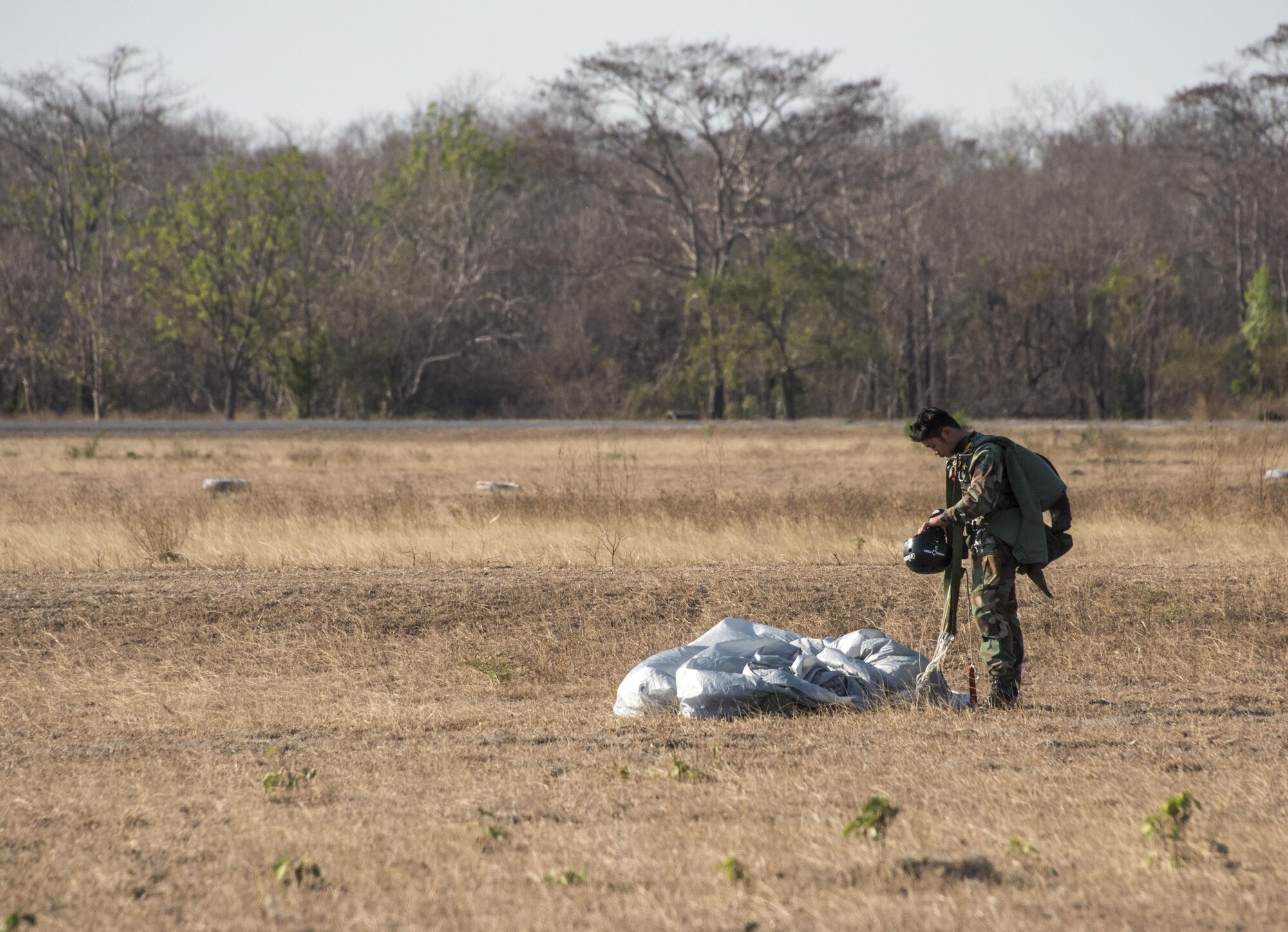 Royal Thai Air Force Special Operations Regiment combat controller gathers parachute equipment following bilateral jump operations from a U.S. Air Force MC-130J Commando II assigned to the 17th Special Operations Squadron, Feb. 16, 2017 at Chandy Range, Thailand. Executing jump operations throughout Cobra Gold 2017, the members of the 320th Special Tactics Squadron and RTAF SOR demonstrated the strength of a partnership that has evolved over the last 17 years. (U.S. Air Force photo by Capt. Jessica Tait)
