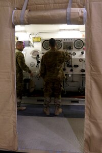 Master diver 1st Sgt. Tyler Dodd with the 511th Engineer Dive Detachment out of Fort Eustis, Va., oversees training of Standard Navy Double Lock Recompression Chamber System while salvage diver Spc. Nathaniel Marquez works the control console, Kuwait Naval Base, Kuwait, Feb. 13, 2017. The training is to give 511th Soldiers hands on training in equipment operation, Soldier advancement and to help a Soldier with an injury sustained during a previous training exercise.