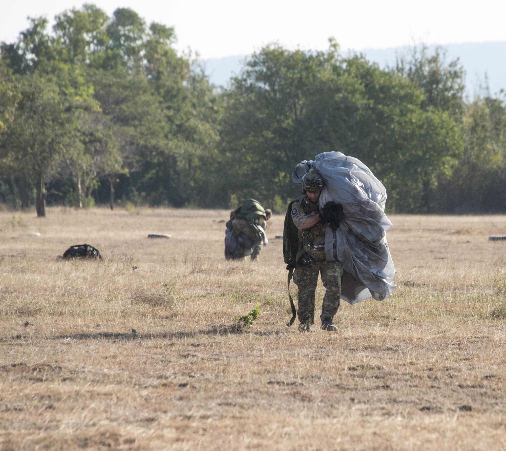 U.S. Air Force combat controllers from the 320th Special Tactics Squadron gather their parachute equipment following military free-fall jumps from a U.S. Air Force MC-130J Commando II assigned to the 17th Special Operations Squadron, Feb. 16, 2017 at Chandy Range, Thailand. The 320th STS executed jump operations with their counterparts from the Royal Thai Air Force Special Operations Regiment throughout Cobra Gold 2017. (U.S. Air Force photo by Capt. Jessica Tait)