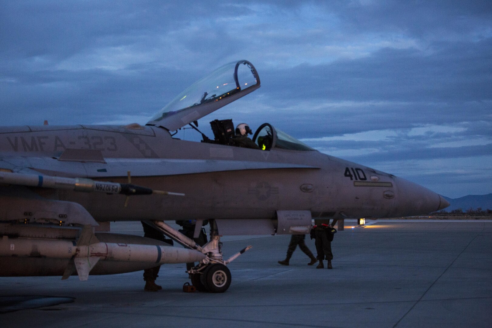 The pilot of an F/A-18C Hornet with Marine Fighter Attack Squadron (VMFA) 323 “Death Rattlers” inspects the aircraft’s functions prior to beginning night operations at Naval Air Station Fallon, Nev., Feb. 15. The Death Rattlers, one of two Marine Hornet squadrons to deploy aboard Navy aircraft carriers, trained at NAS Fallon to strengthen tactical air integration, fulfill predeployment requirements and build rapport with the Navy squadrons they will deploy with in summer 2017. (U.S. Marine Corps photo by Sgt. Lillian Stephens/Released)