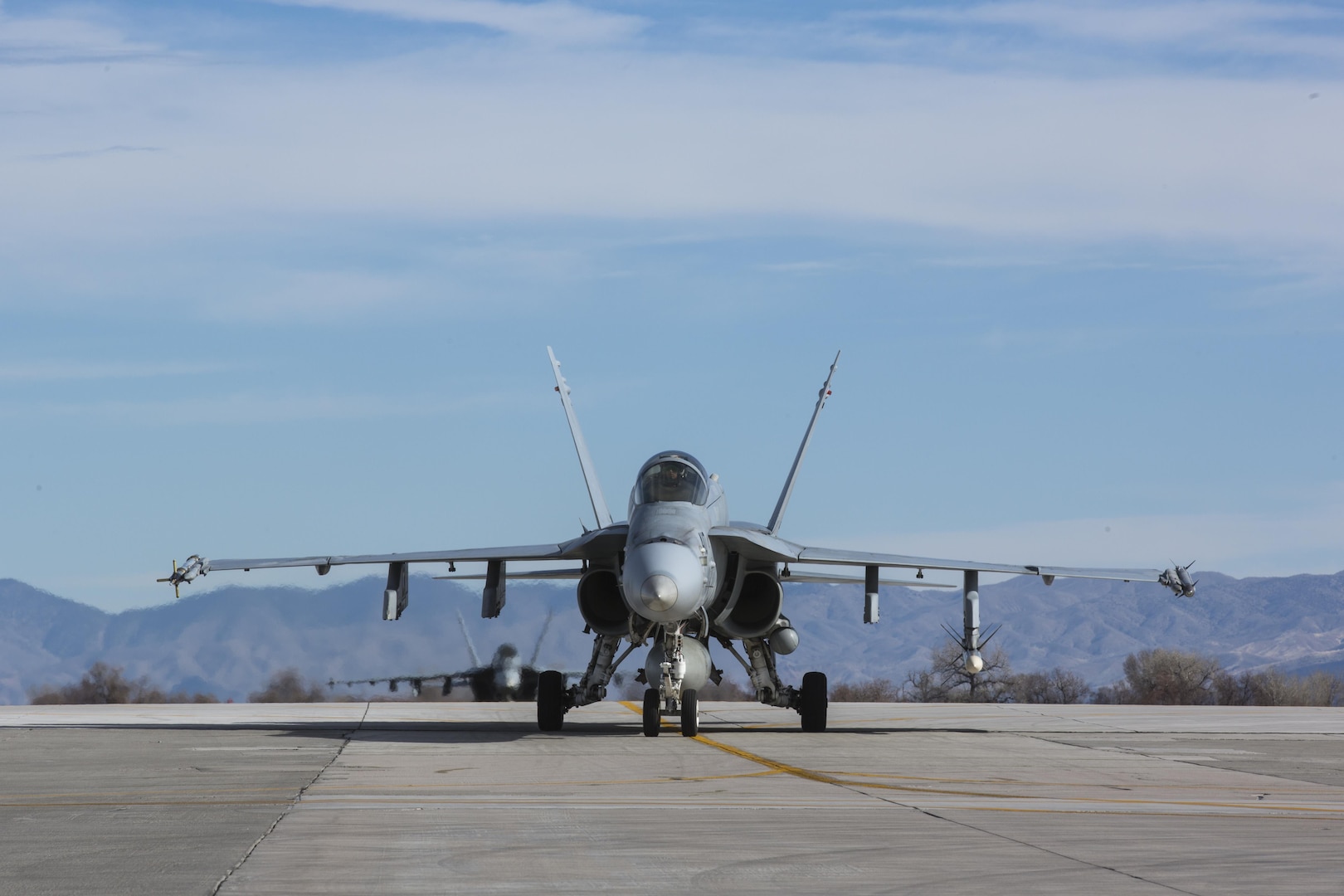 Two F/A-18C Hornets with Marine Fighter Attack Squadron (VMFA) 323 “Death Rattlers” approach the squadron’s designated area of the flight line at Naval Air Station Fallon, Nev., Feb. 15. The Death Rattlers, one of two Marine Hornet squadrons to deploy aboard Navy aircraft carriers, trained at NAS Fallon to strengthen tactical air integration, fulfill predeployment requirements and build rapport with the Navy squadrons they will deploy with in summer 2017. (U.S. Marine Corps photo by Sgt. Lillian Stephens/Released)