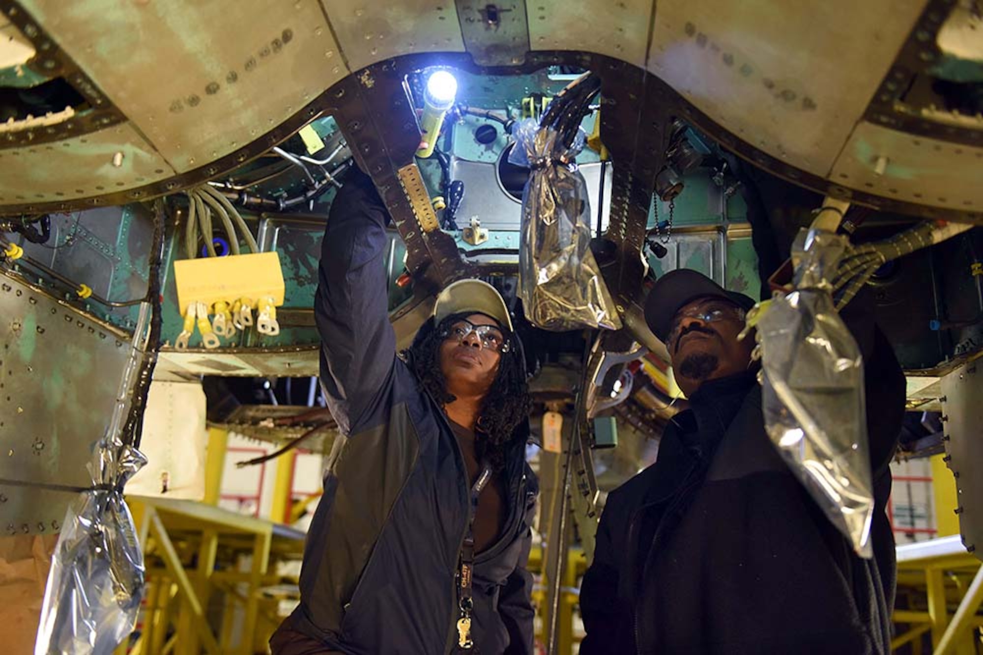 Tanya Thompson, 561st Aircraft Maintenance Squadron aircraft worker, and Alvin Abraham, 561st AMXS aircraft hydraulic systems technician, install hydraulic lines in the airframe mounted accessory drive area of an F-15 during depot maintenance Feb. 16, 2017, at Robins Air Force Base. (U.S. Air Force photo by Tommie Horton/Released)