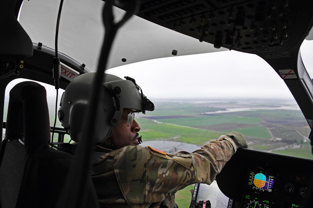 Army National Guard Chief Warrant Officer Shaun Hollins pilots a UH-72 Lakota helicopter, with Chief Warrant Officer II Scott Englebrick, not shown, as Army National Guard Sgt. 1st Class Marty Ortiz documents the flood damage and assessment over Merced County, Merced, Calif., Feb. 19, 2017. Hollins is a pilot assigned to the California Army National Guard’s 1st Battalion, 140th Air Assault Regiment. Air National Guard photo by Senior Airman Daniel Crosier