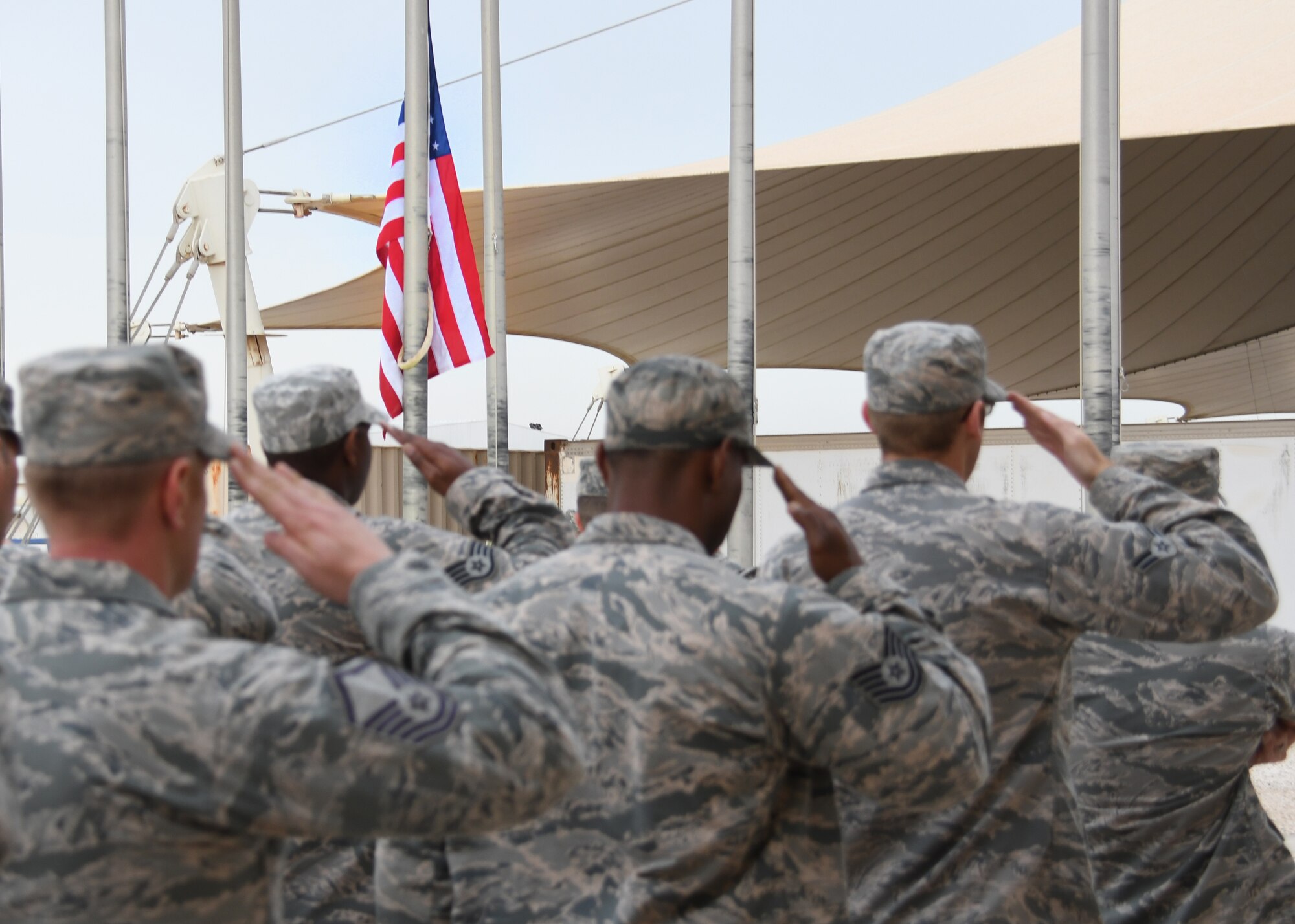 U.S. Airmen salute as the U.S. flag is lowered during a Presidents Day retreat ceremony at Al Udeid Air Base, Qatar, Feb. 20, 2017. Airmen from the across the 379th Air Expeditionary Wing came together to celebrate Presidents Day and honor the lives of those who have served as Commander In Chief. (U.S. Air Force photo by Senior Airman Miles Wilson)
