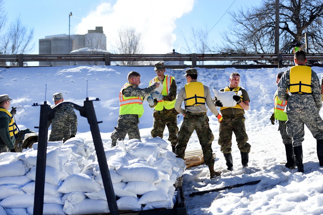 Army National Guard soldiers pass sandbags to reinforce berms along the Bighorn River in downtown Worland, Wyo., Feb. 12, 2017. Army National Guard photo by Sgt. 1st Class Jimmy McGuire