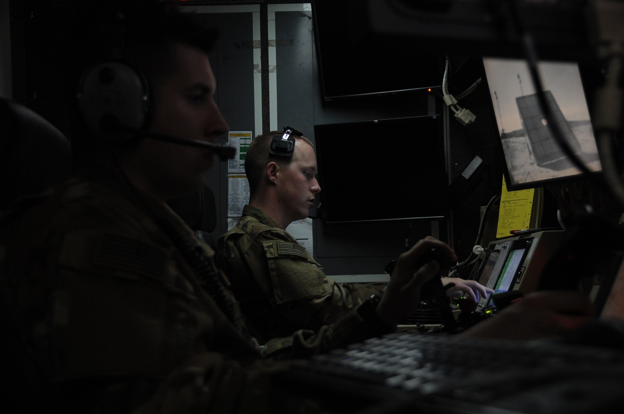 Senior Airman James, left, 46th Expeditionary Reconnaissance Squadron sensor operator, and 1st Lt. Matthew, right, 46th ERS pilot, sit inside a ground station control at an undisclosed location in Southwest Asia Feb. 14, 2017. The 46th ERS Airmen conduct launch and recoveries of MQ-1 Predator remotely piloted aircraft in support of Operation Inherent Resolve. (U.S. Air Force photo/Tech. Sgt. Kenneth McCann)