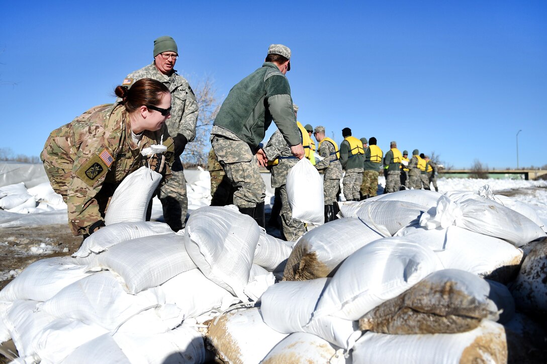 Army National Guard soldiers stack sandbags to reinforce berms along the Bighorn River in Worland, Wyo., Feb. 13, 2017. Army National Guard photo by Sgt. 1st Class Jimmy McGuire