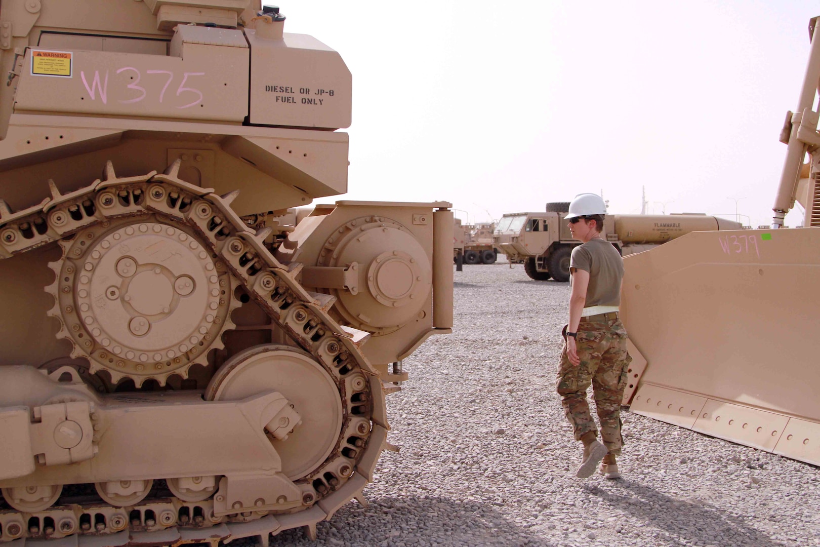 Army Staff Sgt. Jenna Vaughn, 1st Theater Sustainment Command’s Iraq Train and Equip Funding noncommissioned officer, inspects bulldozers received for ITEF July 12, 2016 in Southwest Asia. Armored bulldozers such as these were provided through DLA Troop Support’s Heavy Equipment Procurement Program and will allow Iraqi combat engineers to more effectively clear convoy routes of roadside bombs and other threats in the ongoing fight against the Islamic State of Iraq and the Levant.