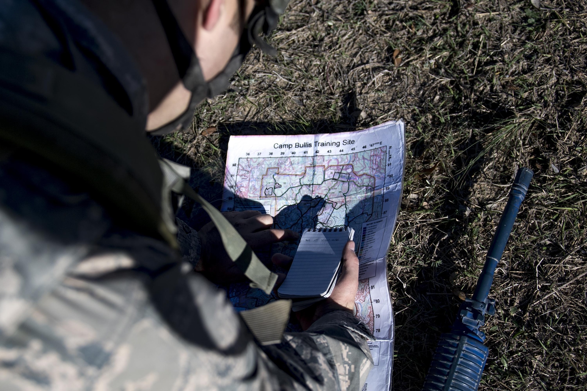 An Air Force Academy Cadet plots location points before conducting land navigation during an Air Liaison Officer Aptitude Assessment, Feb. 15, 2017, at Camp Bullis, Texas. The cadets were ambushed by cadre firing blanks multiple times during the land navigation portion of their assessment. (U.S. Air Force photo by Airman 1st Class Daniel Snider)