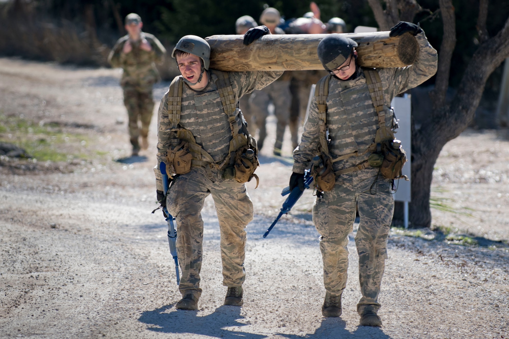 Air Force Academy cadets carry a log over their shoulders during a medical evacuation march at an Air Liaison Officer Aptitude assessment, Feb. 16, 2017, at Camp Bullis, Tx. The cadets were required to trek multiple miles carrying logs and simulated wounded to a medical evacuation zone in limited time. (U.S. Air Force photo by Airman 1st Class Daniel Snider)