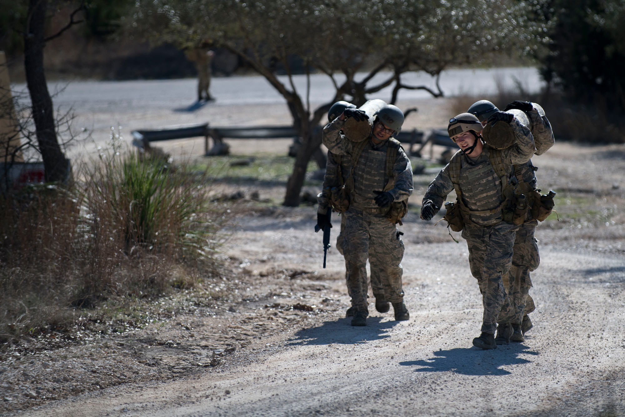 Air Force Academy cadets carry a logs over their shoulders during a medical evacuation march at an Air Liaison Officer Aptitude assessment, Feb. 16, 2017, at Camp Bullis, Texas. The cadets were required to trek multiple miles carrying logs and simulated wounded to a medical evacuation zone in limited time. (U.S. Air Force photo by Airman 1st Class Daniel Snider)