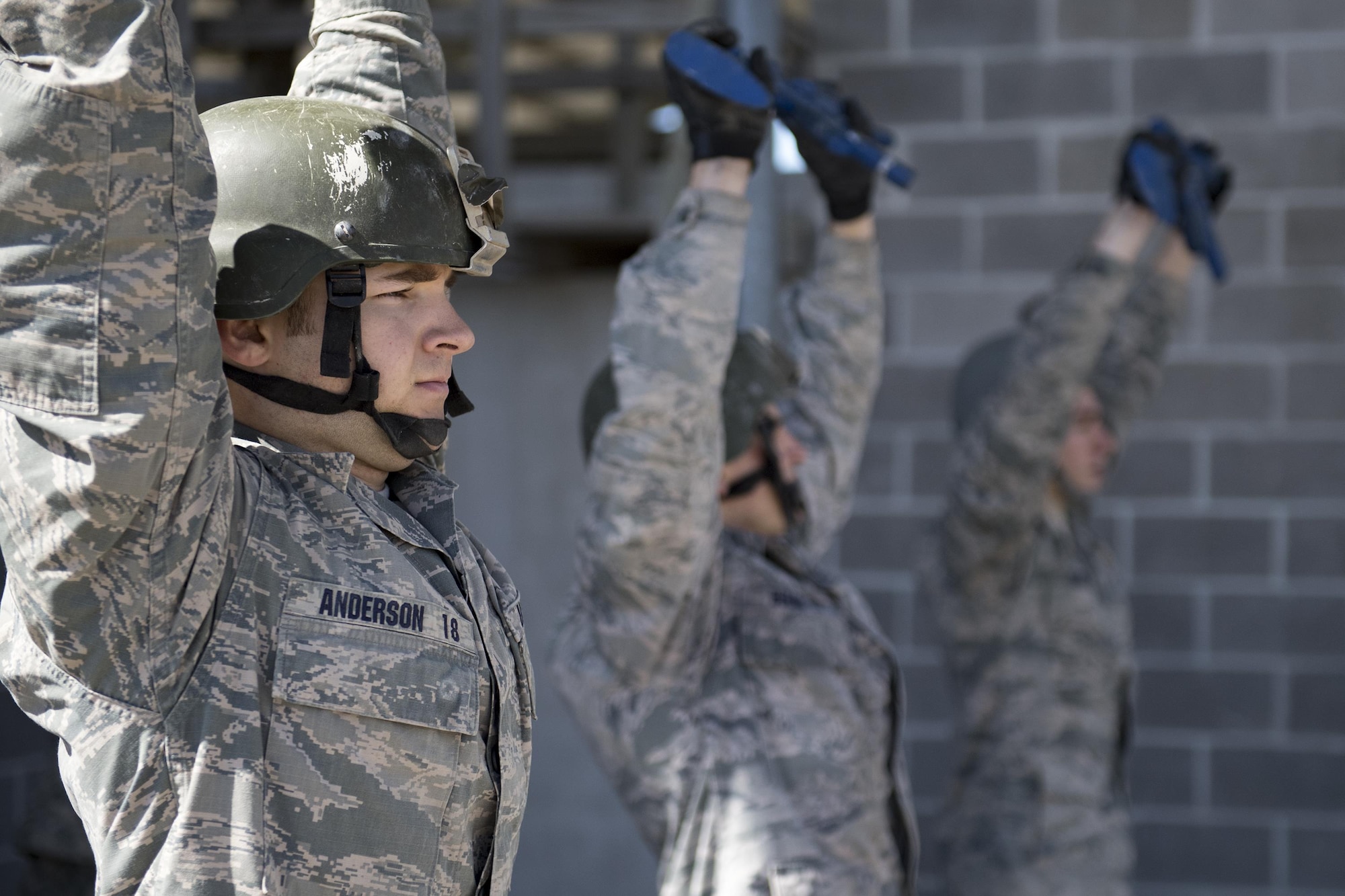 Air Force Academy Cadet Anderson holds a training rifle above his head during tasked obstacle training at an Air Liaison Officer Aptitude assessment, Feb. 14, 2017, at Camp Bullis, Texas. The cadets were divided into two groups for the tasked obstacle portion of the assessment, leaving the other group time to work out. (U.S. Air Force photo by Airman 1st Class Daniel Snider)