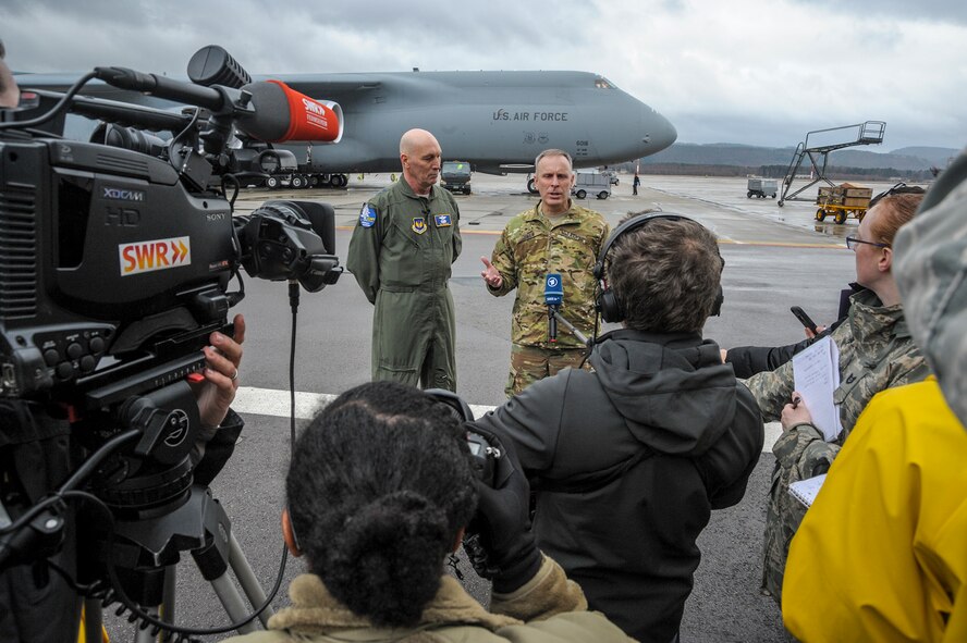 Maj. Gen. Timothy Zadalis, vice-commander, U.S. Air Forces in Europe and Air Forces Africa, and Army Brig. Gen. Phillip Jolly, Deputy Commanding General, Mobilization and Reserve Affairs Director, speak to reporters during the arrival of four Army AH-64 Apache helicopters at Ramstein Air Base, Germany Feb. 22, 2017. The Apache's arrived on two Air Mobility Command C-5M Galaxies. (U.S. Air Force photo/Staff Sgt. Timothy Moore)