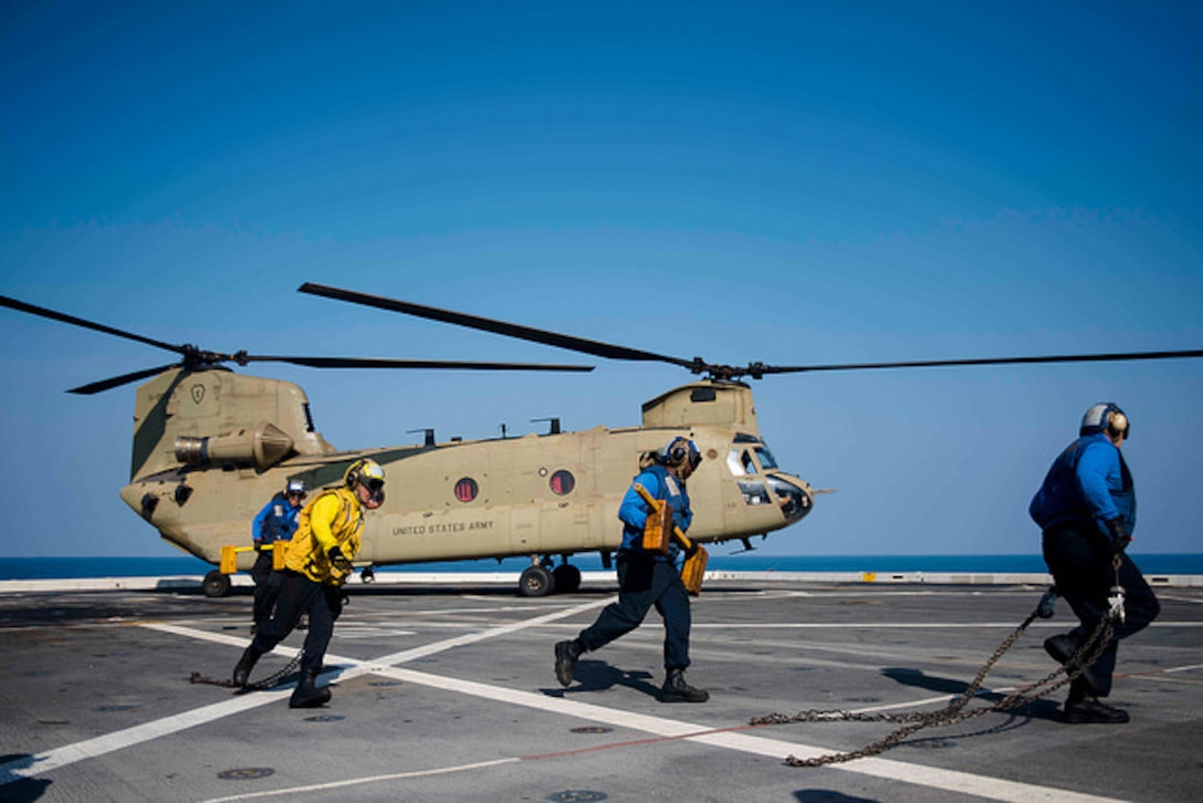 Air department personnel take chocks and chains off of a U.S. Army CH-47F Chinook helicopter aboard the amphibious transport dock ship USS Green Bay during Exercise Cobra Gold, Feb. 21, 2017. Cobra Gold is the largest theater security cooperation exercise in the Indo-Asia-Pacific region and is an integral part of the U.S. commitment to strengthen engagement in the region. Navy photo by Petty Officer 1st Class Chris Williamson