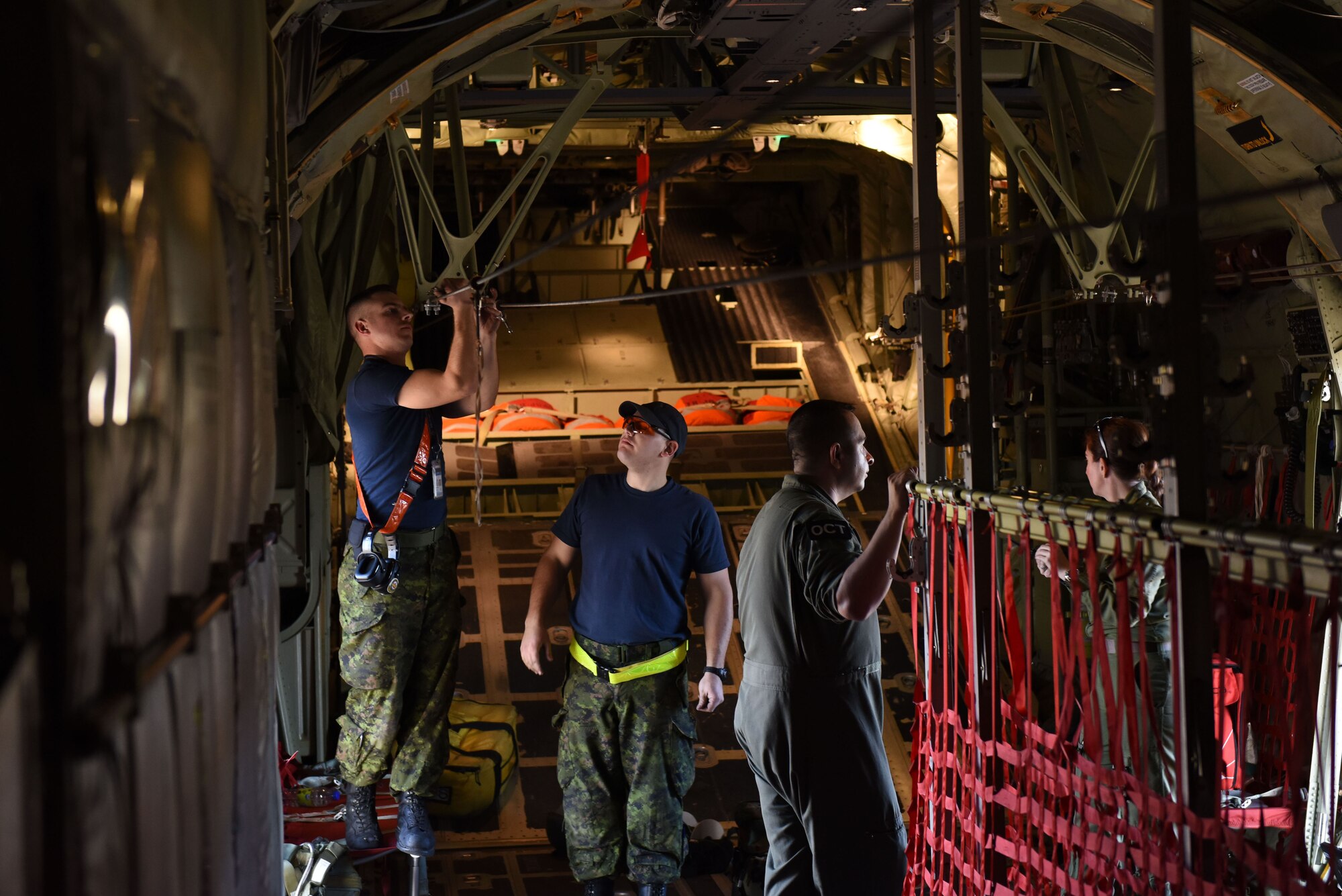 Royal Canadian Air Force aircraft maintenance technicians from the 436 Transport Squadron secure a static line before flight on a C-130J Feb. 10, 2017, at Little Rock Air Force Base, Ark. The RCAF prepared to airdrop U.S. Army personnel from the 509th Infantry Regiment for a mission during Green Flag Little Rock 17-04. (U.S. Air Force photo by Senior Airman Mercedes Taylor)