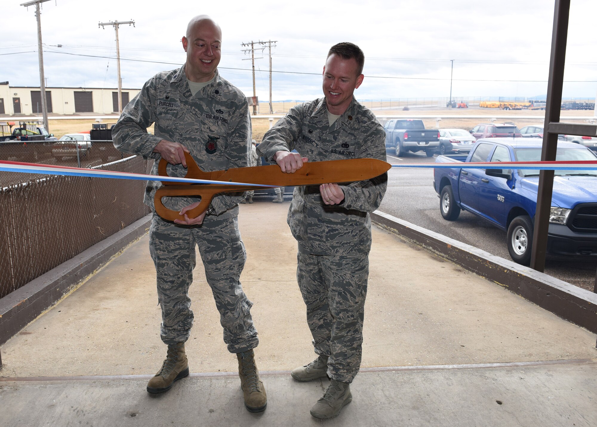 Lt. Col. Joel Purcell, 341st Civil Engineer Squadron commander, left, and Maj. Ryan Murray, 341st Logistics Readiness Squadron commander, take part in a ribbon-cutting ceremony Feb. 21, 2017, at Malmstrom Air Force Base, Mont., to officially recognize the supply warehouse being the centralized location of shipping and receiving cargo for base support. It also serves as the central location for personnel needing assistance for shipment of household goods and shipping privately owned vehicles.  (U.S. Air Force photo/Jason Heavner)