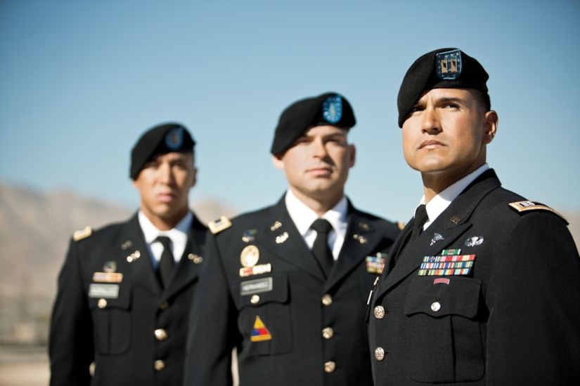Captain Ricardo Romo, First Lieutenant Daniel Hernandez, and Second Lieutenant Andrés Morales wearing dress blues standing together outside during the day.