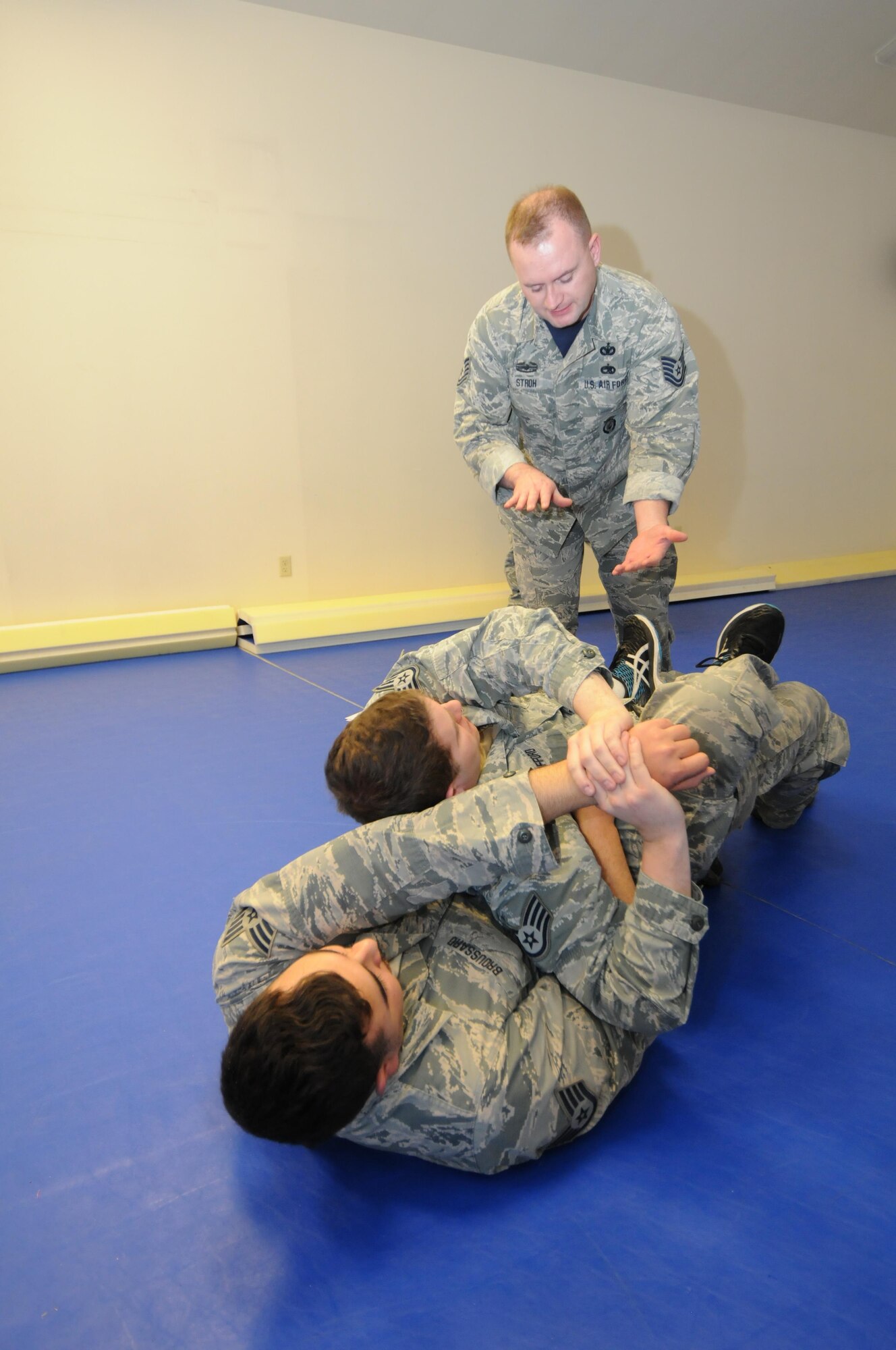 U.S. Air Force Tech. Sgt. Brandan Stroh, a combatives training instructor with the 173rd Security Forces Squadron, instructs Staff Sgt. Nathan Gifford, 173rd SFS,  on how protect himself and subdue an assailant during a hand-to-hand altercation, Jan. 13, 2017. Staff Sgt. Cody Broussard (bottom) an experienced combatives practitioner plays the role of the aggressor. (U.S. Air National Guard photo by Tech. Sgt. Jefferson Thompson)