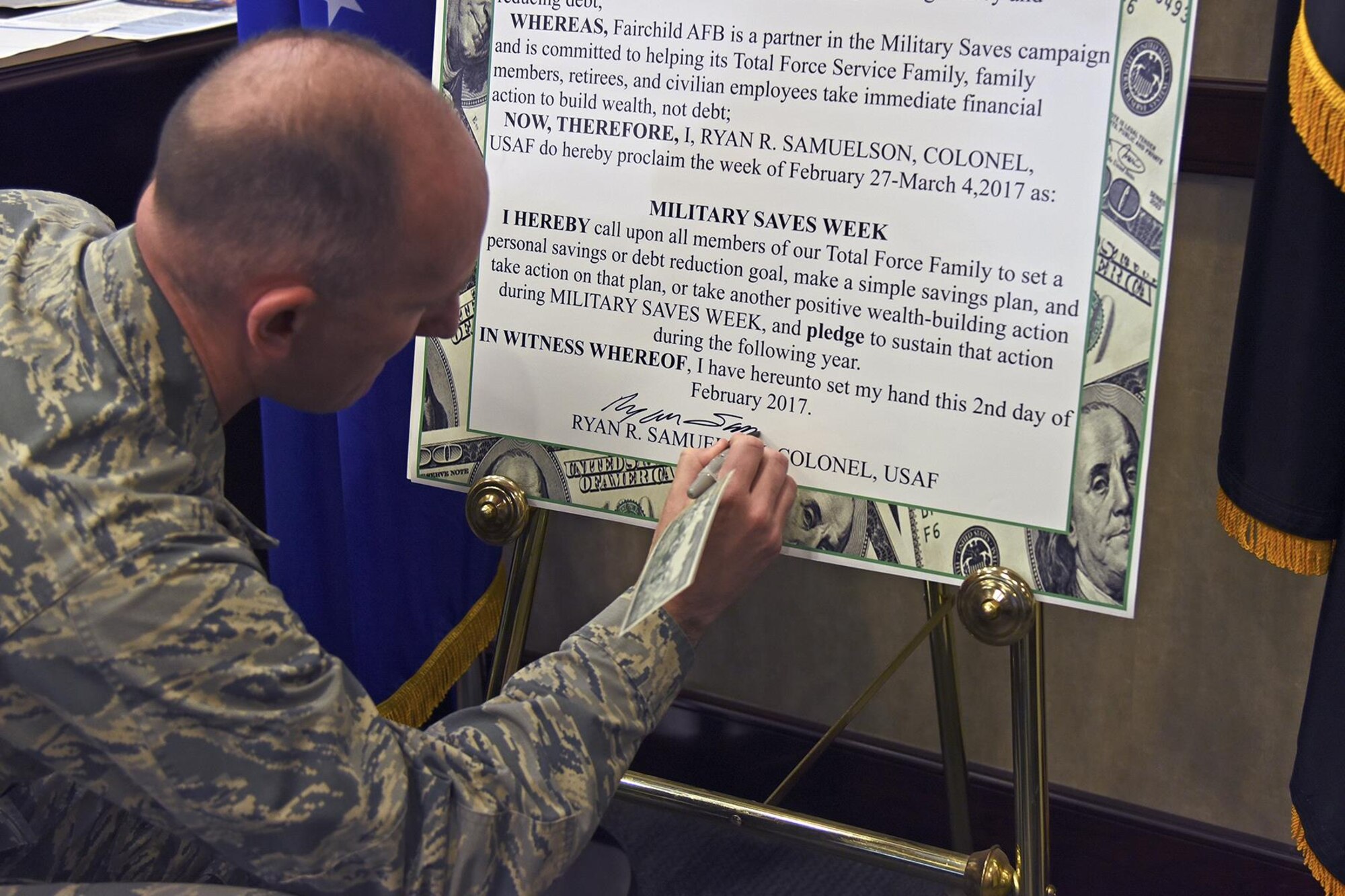 Col. Ryan Samuelson, 92nd Air Refueling Wing commander, signs the Military Saves Week proclamation Feb. 2, 2017, at Fairchild Air Force Base, Washington. Military Saves Week is an annual opportunity held in February for installations and organizations to promote good savings behavior and a chance for service members and their families to assess their own saving status. (U.S. Air Force photo/Senior Airman Mackenzie Richardson)