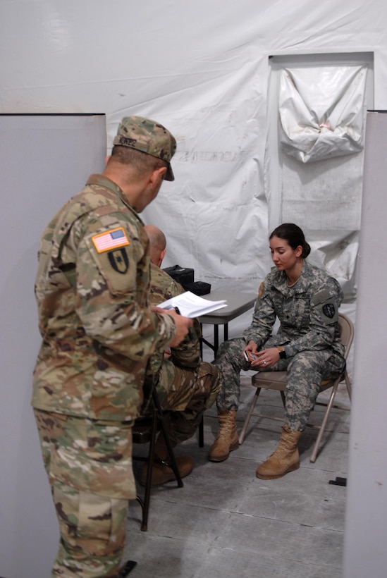 Spc. Rachel Barber, a U.S. Army Reserve Soldier with Army Reserve Medical Command’s 7227th Medical Support Unit, discusses a series of symptoms at the sick call clinic as a mock patient testing the responses of practical nursing specialist, Sgt. Donald Schneider, while observer coach/trainer Lt. Col. Jose Nunez evaluates the scenario for correct responses.  The scenarios placed on Soldiers within the 7227th are training and validation injects in preparation for the unit’s upcoming mobilization in support of Landstuhl Regional Medical Center’s Deployed Warrior Medical Management Center.  Soldiers assigned to the 7227th MSU, out of Columbia, Missouri, have been working alongside 1st Army Division West’s observer coach/trainers with 4th Battalion (Medical), 393rd Infantry Regiment in North Fort Hood for three weeks in preparation for their upcoming mission.