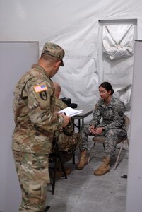 Spc. Rachel Barber, a U.S. Army Reserve Soldier with Army Reserve Medical Command’s 7227th Medical Support Unit, discusses a series of symptoms at the sick call clinic as a mock patient testing the responses of practical nursing specialist, Sgt. Donald Schneider, while observer coach/trainer Lt. Col. Jose Nunez evaluates the scenario for correct responses.  The scenarios placed on Soldiers within the 7227th are training and validation injects in preparation for the unit’s upcoming mobilization in support of Landstuhl Regional Medical Center’s Deployed Warrior Medical Management Center.  Soldiers assigned to the 7227th MSU, out of Columbia, Missouri, have been working alongside 1st Army Division West’s observer coach/trainers with 4th Battalion (Medical), 393rd Infantry Regiment in North Fort Hood for three weeks in preparation for their upcoming mission.