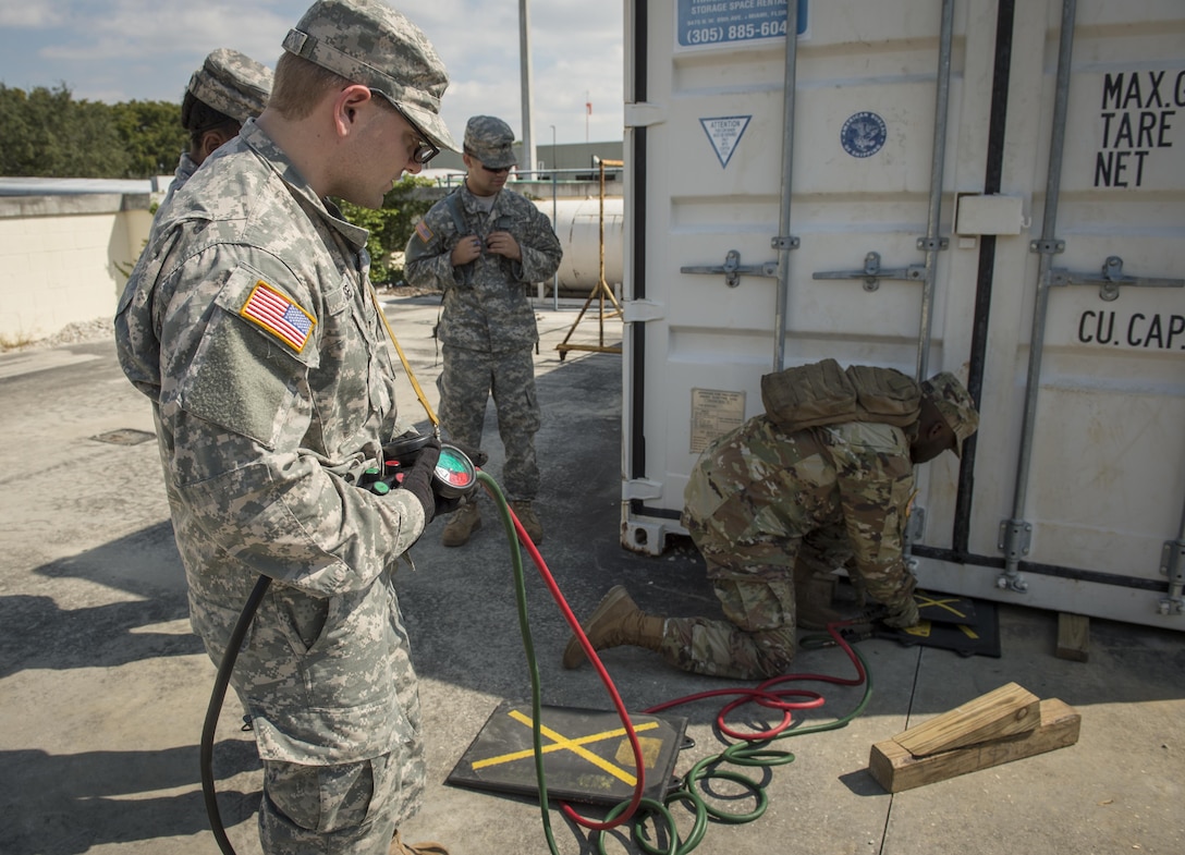 U.S. Army Reserve Spc. Alexander Isley (left), and Spc. Roderick Vickers, 329th Chemical Company chemical biological warfare specialist, operate lifting equipment during hazardous material training on Miami-Dade Fire Rescue headquarters, Miami, Fl. Feb 17, 2016. These training events were held by fire rescue personnel in preparation for a validation exercise held by U.S. Army North and U.S. Northern Command. 