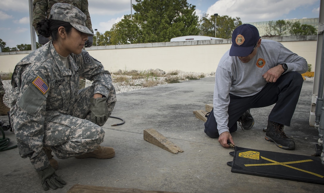 Lt. Chris Pecori, Miami-Dade Fire Rescue air rescue training officer, briefs proper equipment placement to  U.S. Army Reserve Spc. Daisy Garcia, 329th Chemical Company chemical biological warfare specialist, operate rescue and containment equipment during hazardous material  training on Miami-Dade Fire Rescue headquarters, Miami, Fl. Feb 17, 2016. These training events were held by fire rescue personnel in preparation for a validation exercise held by U.S. Army North and U.S. Northern Command. 