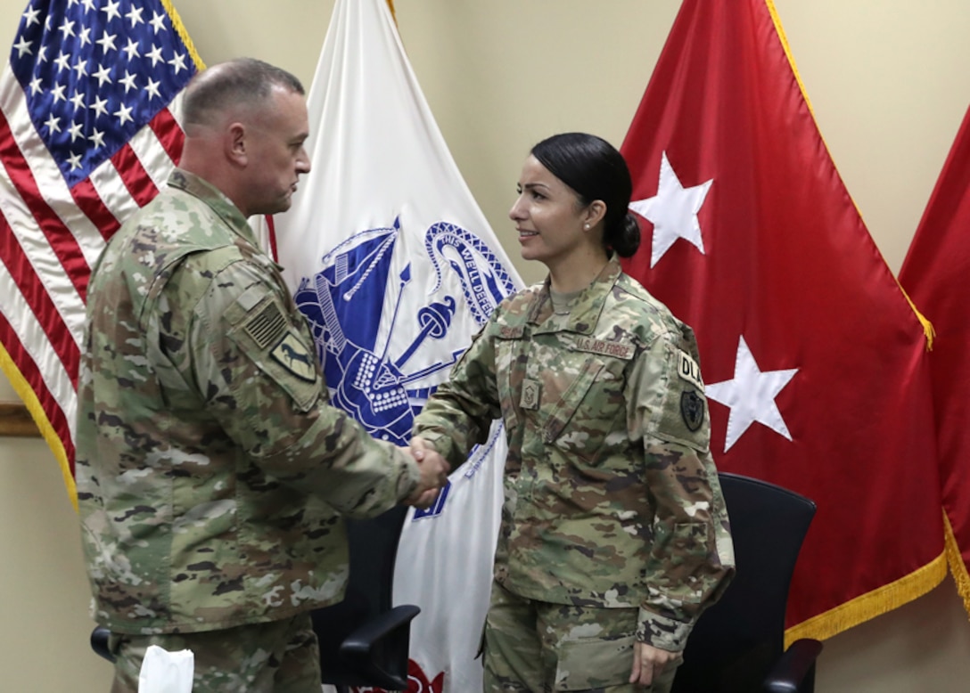 316th Expeditionary Sustainment Command Commanding General Army Brig. Gen. Robert Harter honors Air Force Tech. Sgt. Janet Pelayo, Defense Logistics Agency Aviation, with his coin at her promotion ceremony Jan 31, 2017 held at Camp Arifjan, Kuwait.