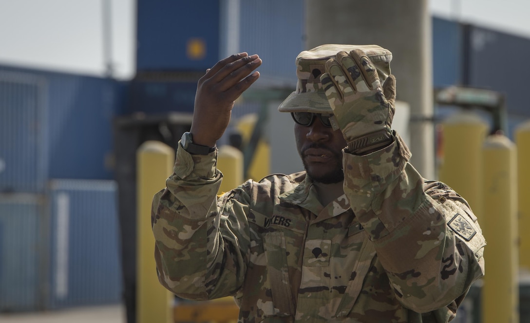 U.S. Army Reserve Spc. Rodrick Vickers, 329th Chemical Company chemical biological warfare specialist, guides off-loading equipment during a hazardous material decontamination exercise on the Port of Miami, Fla. Feb 18, 2017. The exercise was led by Miami-Dade Fire Rescue and U.S. Army North under the supervision of U.S. Northern Command and provided soldiers and first responders the unique experience of operating together in a major metropolitan city. 