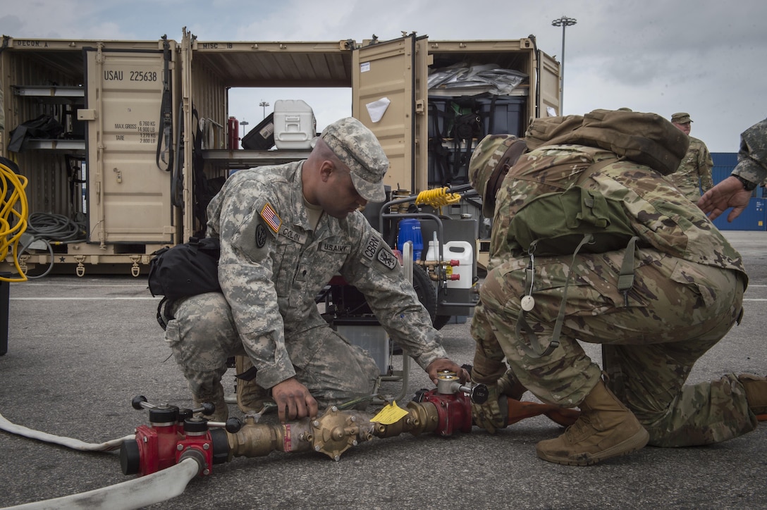 U.S. Army Reserve Spc. Luis Colon (left) and Spc. Rodrick Vickers, 329th Chemical Company chemical biological warfare specialists, prepares a water hose for a decontamination tent during a hazardous material exercise on the Port of Miami, Fla. Feb 18, 2017.The exercise was led by Miami-Dade Fire Rescue and U.S. Army North under the supervision of U.S. Northern Command and provided soldiers and first responders the unique experience of operating together in a major metropolitan city. 