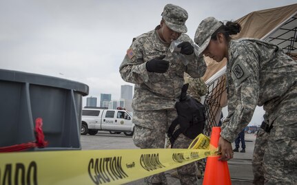 Cpl. Shalandis Johnson (left) and Spc. Daisy Garcia, 329th Chemical Company chemical biological warfare specialists, begin cordon procedures during a hazardous material decontamination exercise on the Port of Miami, Fla. Feb 18, 2017.The exercise was led by Miami-Dade Fire Rescue and U.S. Army North under the supervision of U.S. Northern Command and provided soldiers and first responders the unique experience of operating together in a major metropolitan city. 