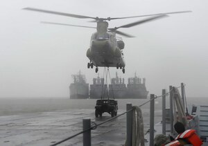 A U.S. Army CH-47 Chinook helicopter transports vehicles to a floating causeway on the James River as part of a sling-load operations exercise at Joint Base Langley-Eustis, Va., Feb. 15, 2017. The field training exercise involved Soldiers from the 331st Transportation Company, 11th Battalion, 7th Transportation Brigade (Expeditionary) working with land, sea and air components to prepare for real-world scenarios such as humanitarian relief or global disasters. (U.S. Air Force photo by Airman 1st Class Kaylee Dubois)