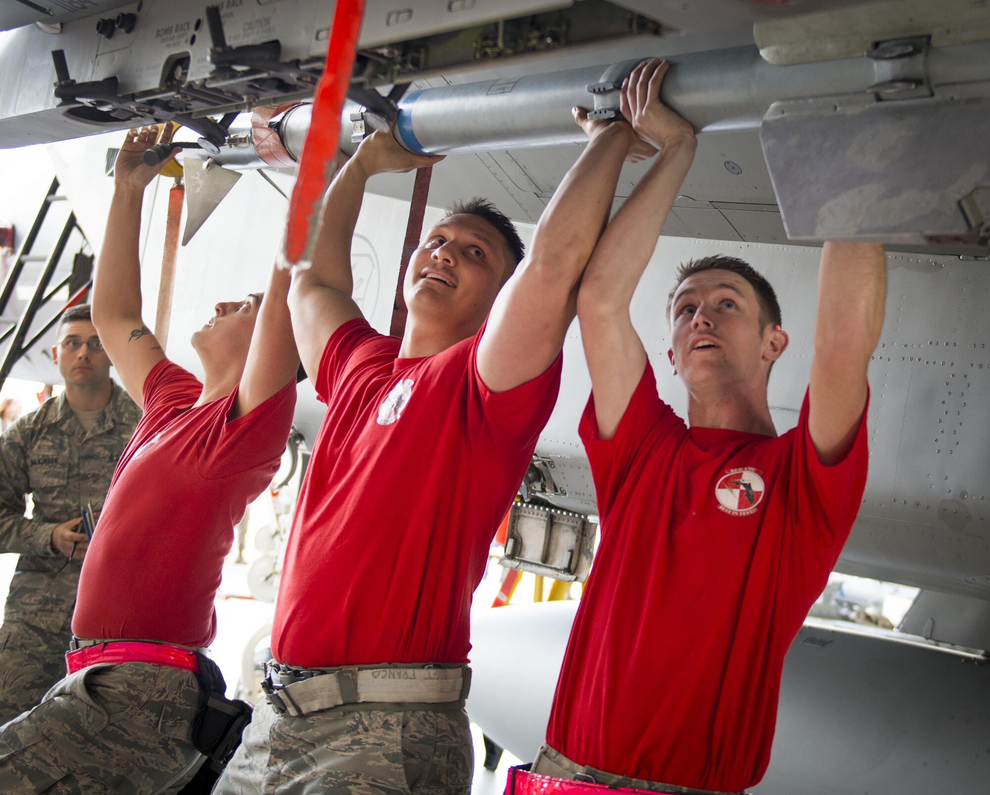Senior Airman Nicholas Brooks, Staff Sgt. Vincent Franco and Senior Airman William Wakeland hoist the 188 pound AIM-9 onto the munition rail of an F-15 Eagle Feb. 17 at Eglin Air Force Base, Fla. The 30-minute competition tests the knowledge and proficiency of the crews. The annual competition also identifies the load crew of the year and earns them bragging rights as the best of 22. The winning crew is scheduled to be announced at the Maintenance Professionals of the Year Banquet in March. (U.S. Air Force photo/Kristin Stewart)