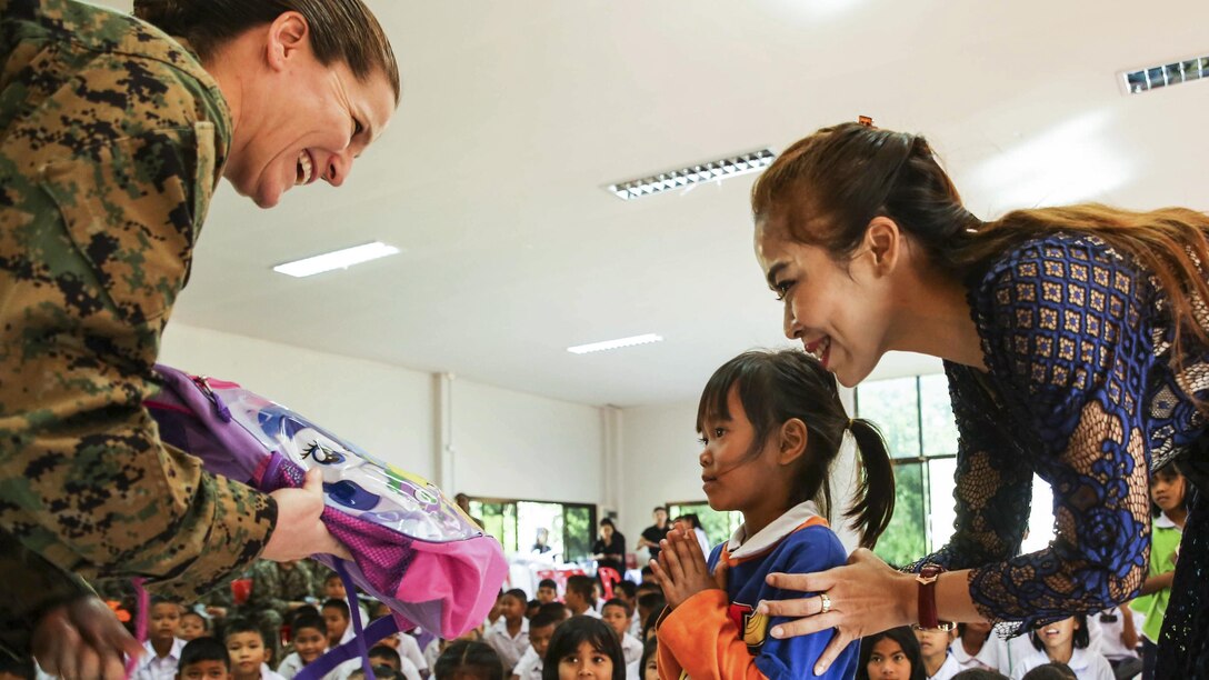 Marine Corps Col. Maria McMillen gives school supplies to a Thai girl at a school in Chanthaburi, Thailand, Feb. 15, 2017. Thai, U.S. and partner nation service members participated in community relation projects throughout Thailand during Cobra Gold 2017, a  humanitarian exercise. McMillen is deputy Marine Forces commander, 1st Marine Aircraft Wing, 3rd Marine Expeditionary Force. Marine Corps photo by Sgt. Tiffany Edwards