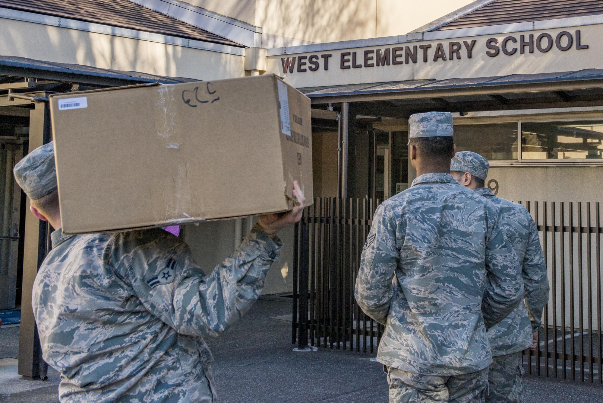 Airmen from the 374th Logistics and Readiness Squadron, and part of the Rising Six, carry boxes of donated school supplies from the Holiday Teacher Drive into West Elementary School Feb. 15, 2017, at Yokota Air Base, Japan. Seven members from the Rising Six gathered $2,400 worth of school supplies and $300 for Yokota Air Base schools. (U.S. Air Force Photos by Airman 1st Class Donald Hudson)