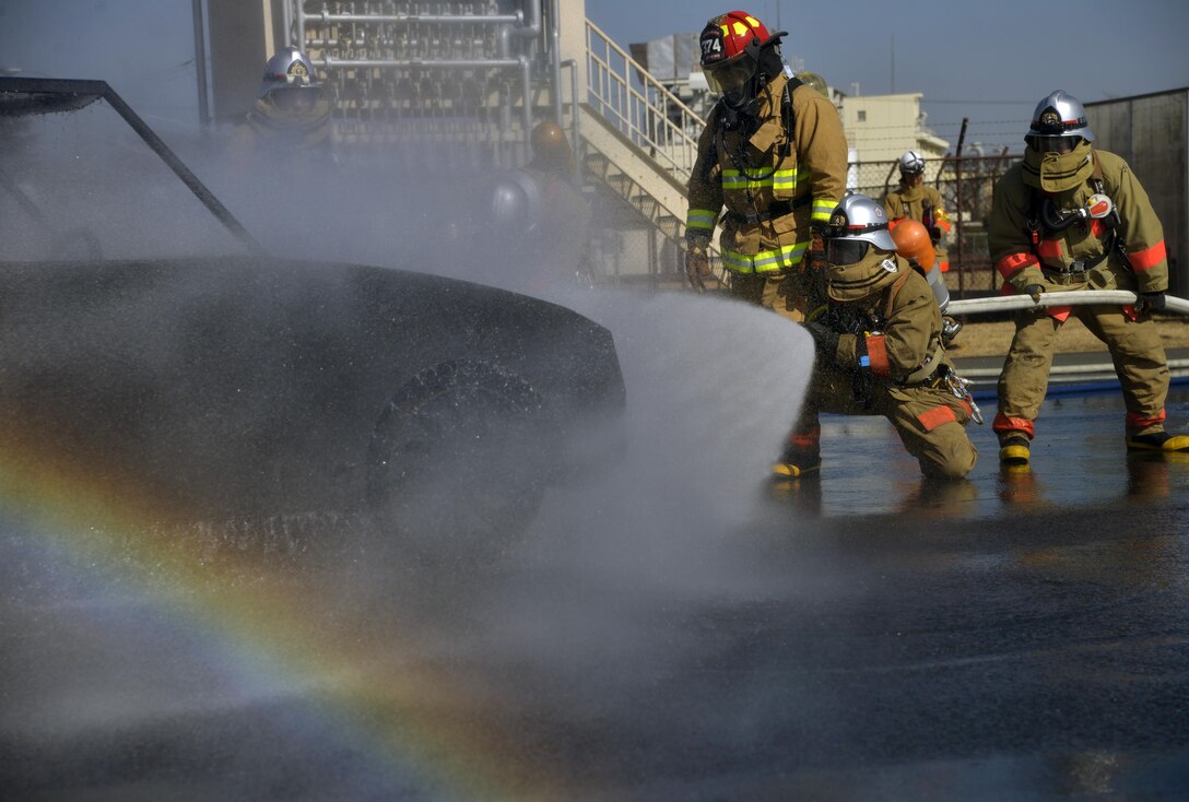 Staff Sgt. Lee Mathews, 374th Civil Engineer Squadron Fire Department crew chief, looks on as fire fighters from the Fussa Fire Department put out a vehicle fire during a fire training scenario at Yokota Air Base, Japan, Feb. 16, 2017. Mathews ensured that the fire fighters completed the training safely. (U.S. Air Force photo by Staff Sgt. David Owsianka)