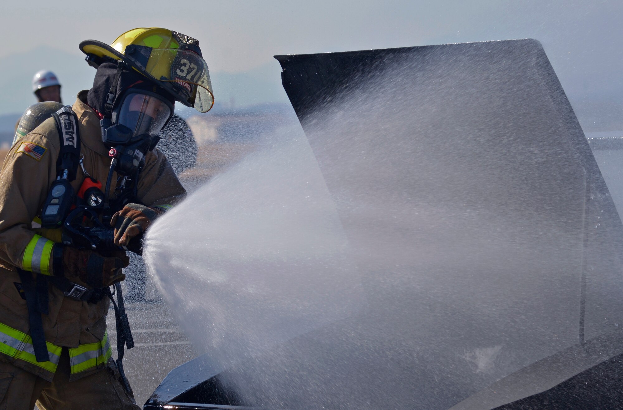 Takuto Hatayama, 374th Civil Engineer Squadron Fire Department fire fighter, puts out an engine fire during a vehicle fire training scenario at Yokota Air Base, Japan, Feb. 16, 2017. Yokota’s personnel trained with the Japan Self-Defense Force and Fussa fire departments to gain different perspectives on putting out vehicle fires. (U.S. Air Force photo by Staff Sgt. David Owsianka)