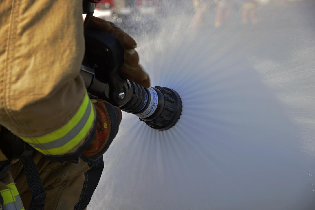 Senior Airman Jordan Spiceland, 374th Civil Engineer Squadron Fire Department fire fighter, performs a test run on a hose prior to completing a vehicle fire training scenario at Yokota Air Base, Japan, Feb. 16, 2017. During this scenario, Spiceland was part of the standby team providing a safety line to help the primary teams in case of an emergency. (U.S. Air Force photo by Staff Sgt. David Owsianka)