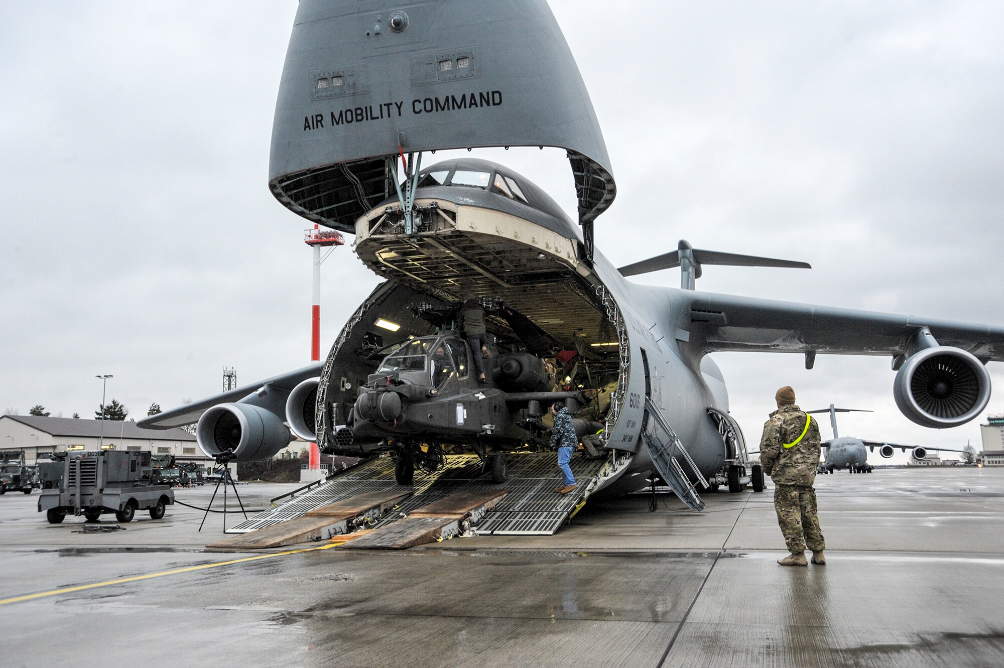 An Army AH-64 Apache helicopter is unloaded from an Air Mobility Command C-5M Galaxy at Ramstein Air Base, Germany, Feb. 22, 2017, in support of Operation Atlantic Resolve.  The four Apache helicopters that arrived are part of a larger contingent of helicopters and personnel comprising of Operation Atlantic Resolve, a U.S. commitment to maintaining peace and stability in the European region.  (U.S. Air Force photo/Staff Sgt. Timothy Moore)
