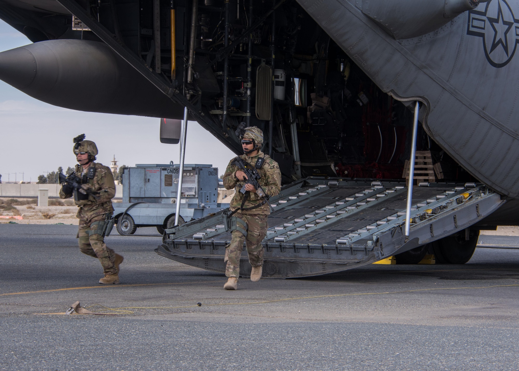 Staff Sgt. Ryan Malicki, left, and Senior Airman Ryan Donato, right, 386th Expeditionary Security Forces Squadron Fly-Away Security Team members, run off the cargo ramp of a C-130H Hercules during a FAST drill at an undisclosed location in Southwest Asia, Feb. 5, 2017. These teams are responsible for protecting the aircraft, its crew members, and the cargo from potential adversaries in austere locations. (U.S. Air Force photo/Senior Airman Andrew Park)